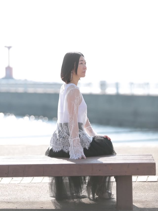 海辺のベンチでポーズをとるあずまる